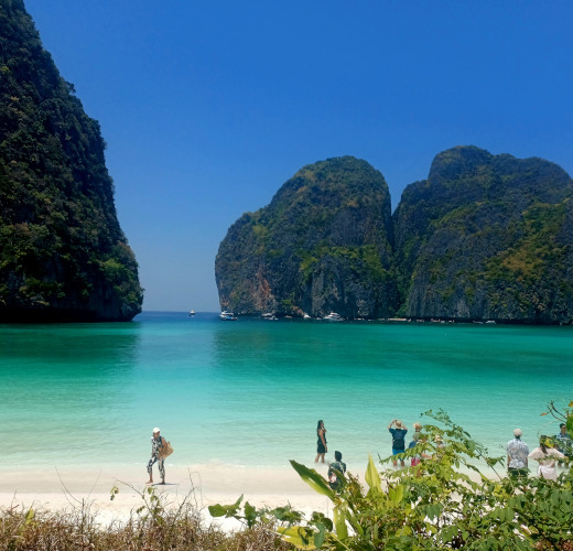 Maya Bay in the Andaman Sea. Sandy beach in the foreground, Turquoise water leading to limestone cliffs.