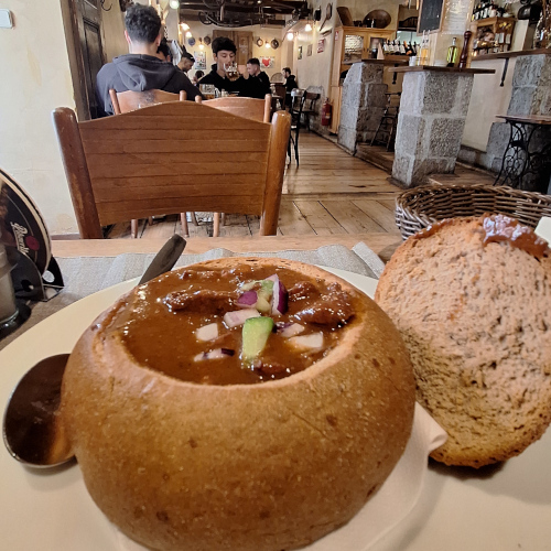 Goulash soup served in sourdough bread at a traditional Prague pub