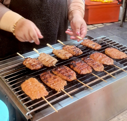 Hawker in Chinatown, Kuala Lumpur, selling delicious grilled chicken kebabs