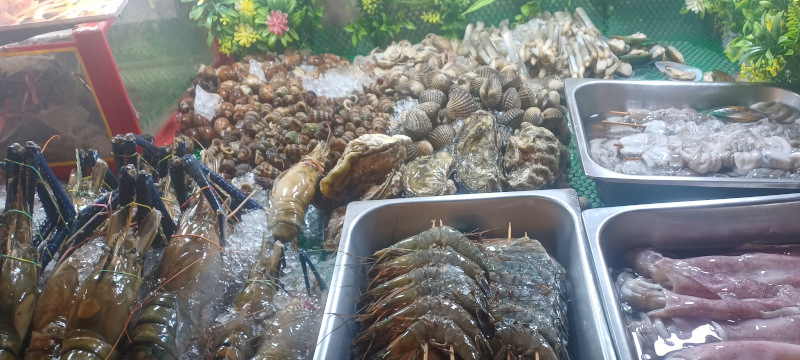 Stall in Chinatown, Kuala Lumpur, packed with fresh seafood, including squid, prawns, and shellfish