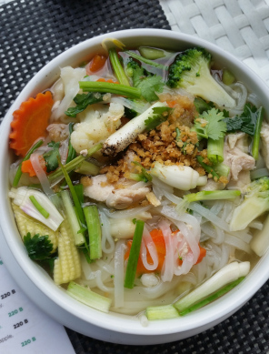 Chicken noodle soup served in a bowl from a restaurant in Pai, North Thailand.