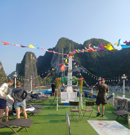 People enjoying drinks on the top deck of the boat in Ha Long Bay