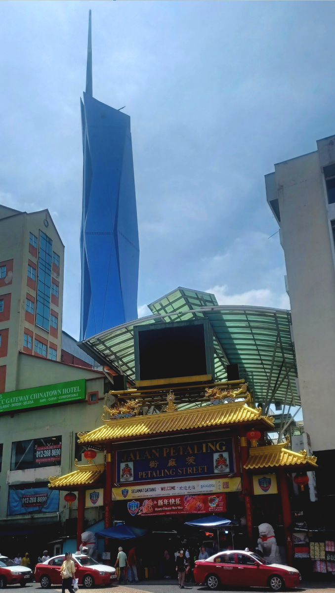 Merdeka 118 skyscraper towering above the entrance to Jalan Petaling Market in Chinatown, showcasing the vibrant atmosphere of the area