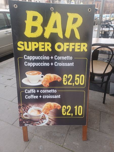 Coffee and Croissant A-Frame Sign – Near Colosseum, Rome A-frame street sign offering croissants and coffee near the Colosseum in Rome
