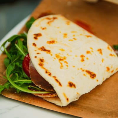Folded Piadina – Ham and Cheese Delight at Termini Food Court, Rome Folded Piadina with ham, arugula, cheese, and tomato from Termini Food Court