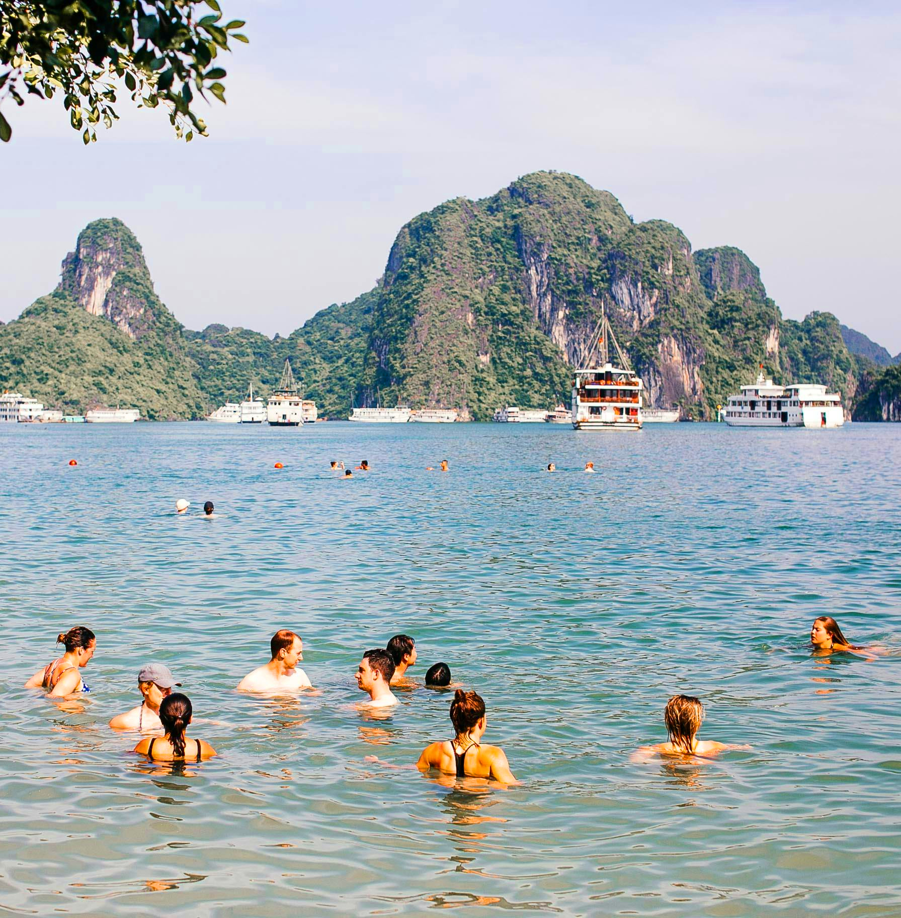 People swimming in the clear waters of Tip Top Island, Ha Long Bay