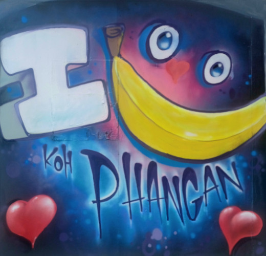 Koh Phangan street art featurin a dark moon with eyes and a banana representing a smile.