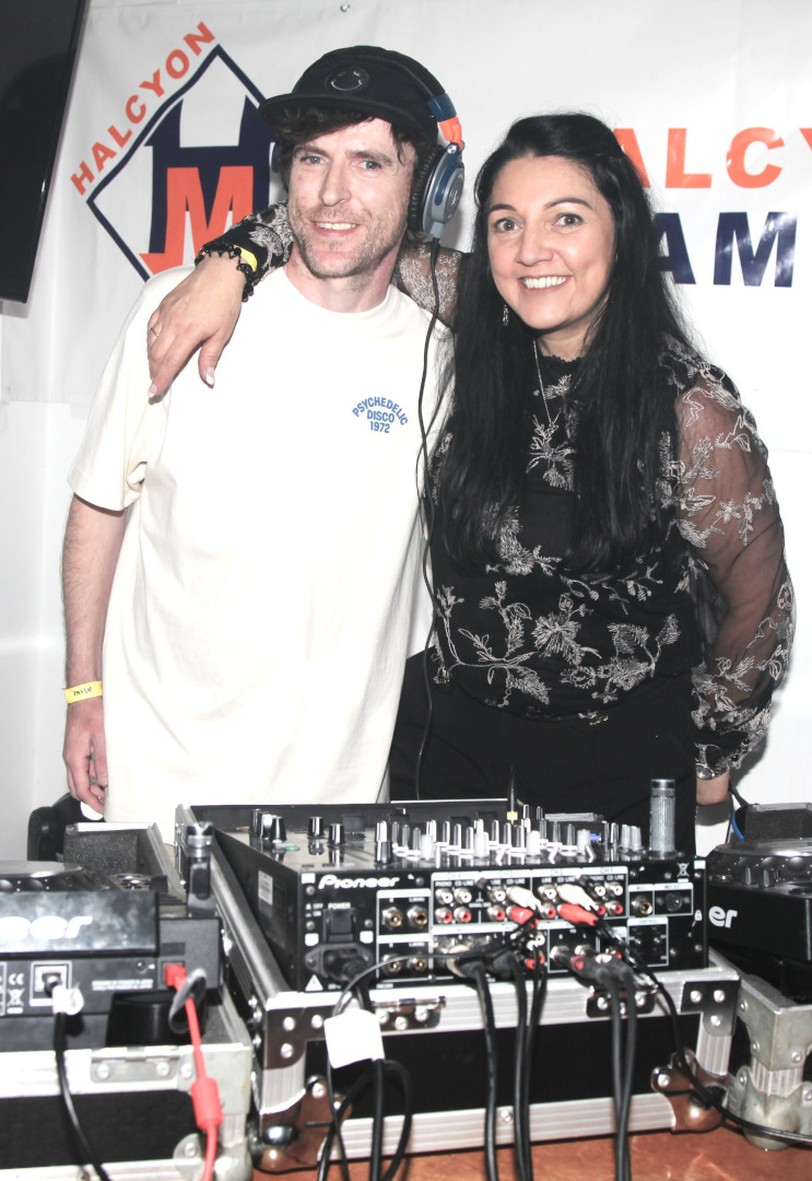Two DJs Performing Behind the Booth with Halcyon Mambo Branding Two DJs behind a booth featuring Halcyon Mambo branding