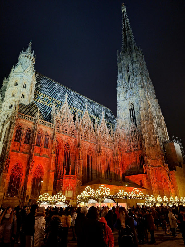 St. Stephen’s Cathedral, Vienna by Night St. Stephen's Cathedral in Vienna illuminated by red uplighters on a winter evening, with people walking outside