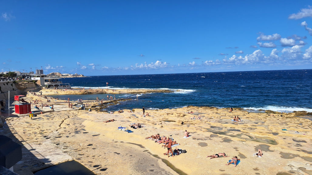 Sunny Day at Sandstone Beach, Sliema Sandstone Beach in Sliema, Malta, with people enjoying the sunshine