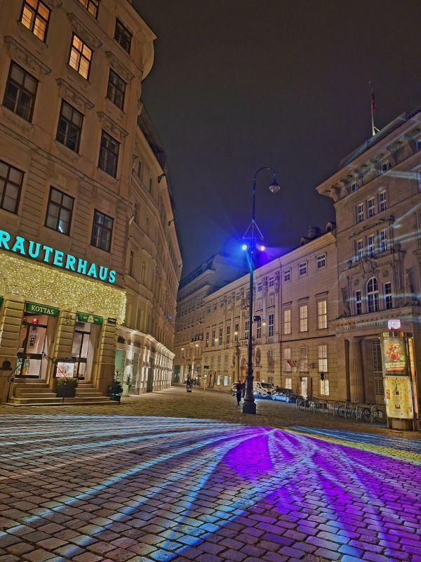 Enchanting Christmas Lights in Vienna Night view of Vienna's architecture lit by streetlamps, with LED lights illuminating the road, creating a magical Christmas atmosphere