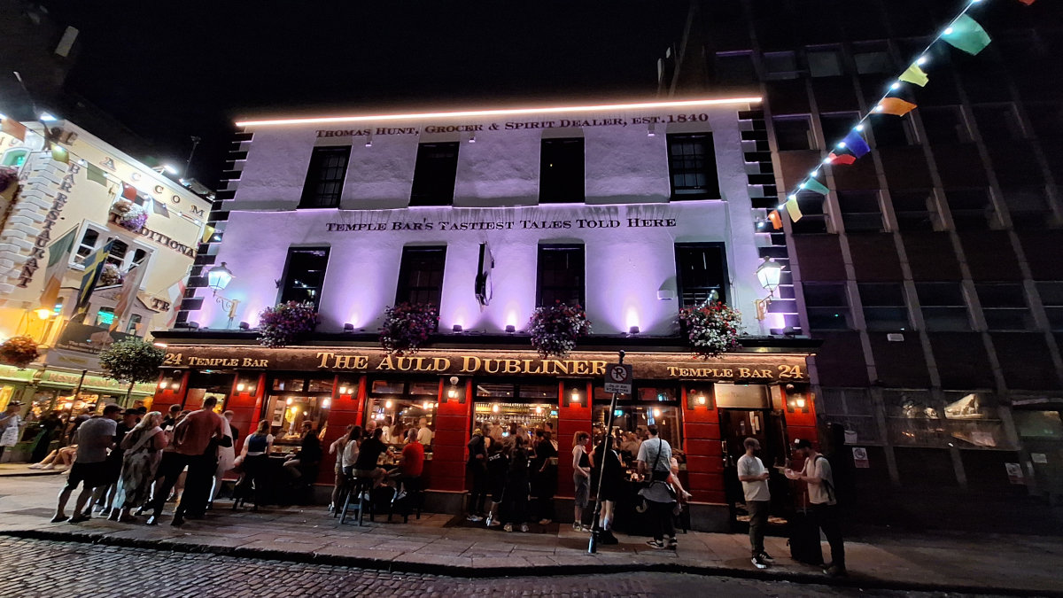 The Auld Dubliner Pub in Temple Bar at Night The Auld Dubliner pub in Temple Bar, Dublin, illuminated at night with people wandering by against an evening sky.