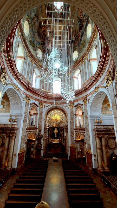Ornate Dome of Karlskirche Cathedral Interior view of Karlskirche Cathedral, looking up at the ornately painted dome and a prominent modern lighting fixture