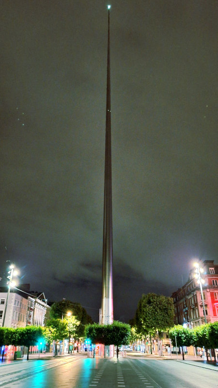 The Spire of Dublin Under a Dark Grey Sky The Spire in Dublin illuminated against a dark grey sky, resembling a scene from a sci-fi movie