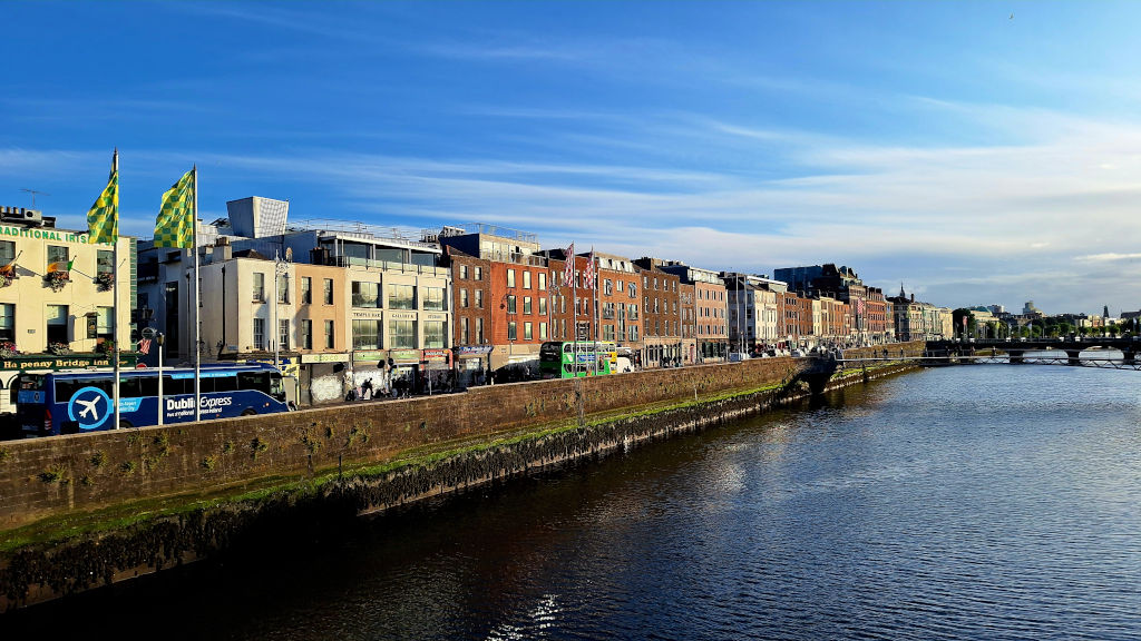 Vibrant River Liffey with Colourful Buildings River Liffey in Dublin lined with brightly colored buildings and buses along one side