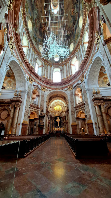Stunning Interior of Karlskirche, Vienna Wide-angle view of the interior dome of Karlskirche in Vienna, featuring modern lighting and the altar in the background