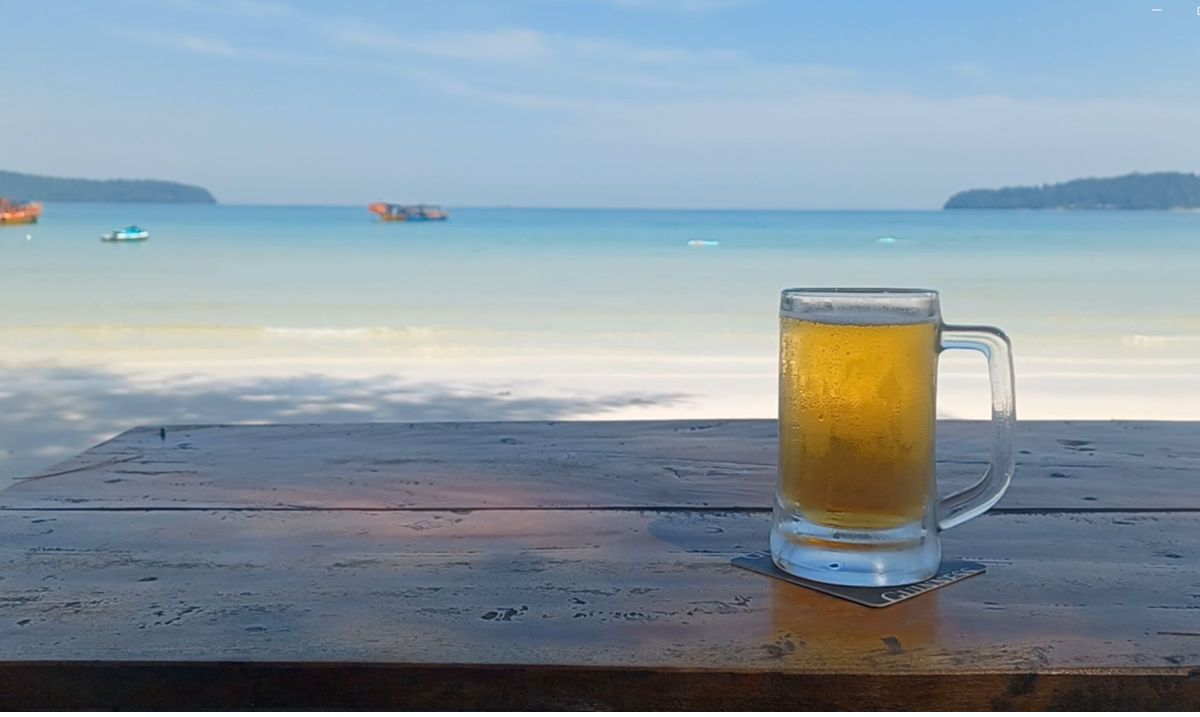 Refreshing Cambodia Draft Beer with Koh Rong Backdrop Close-up of a cold Cambodia draft beer set against the sea and sky on Koh Rong