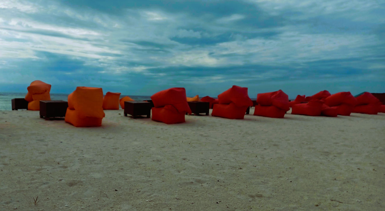 Colourful Red Bean Bags on Gili Trawangan Beach Line of red bean bags on powdery white sand at Gili Trawangan with a dramatic blue sky