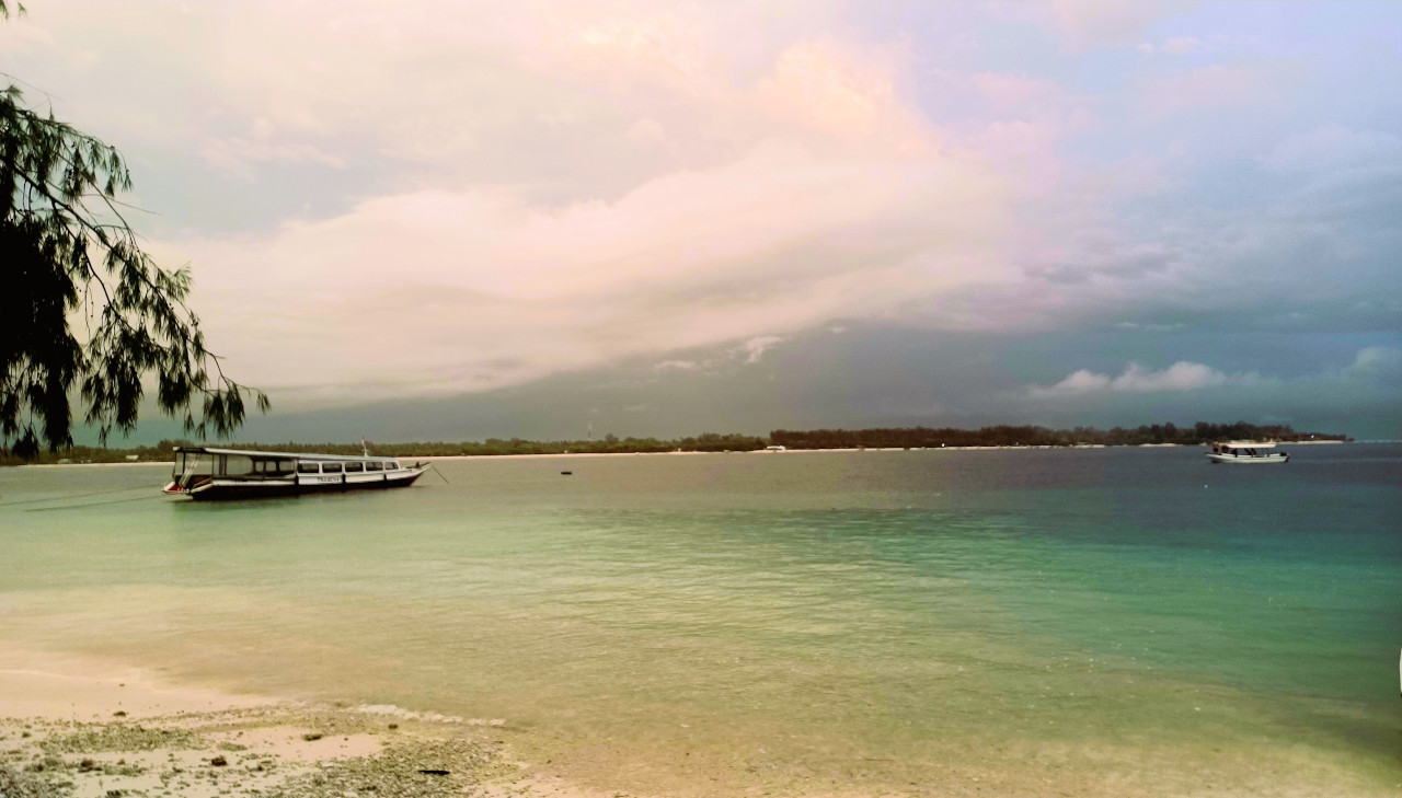 Serene Waters of Gili Trawangan Calm waters of Gili Trawangan with boats floating peacefully on the surface