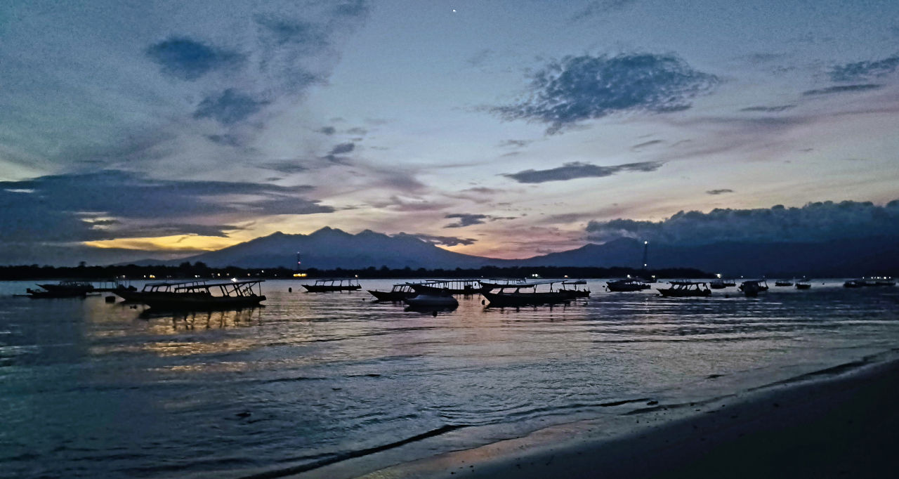 Sunrise view from Gili Trawangan with boats and Mount Rinjani on Lombok visible on the horizon Sunrise view from Gili Trawangan with boats and Mount Rinjani on Lombok visible on the horizon